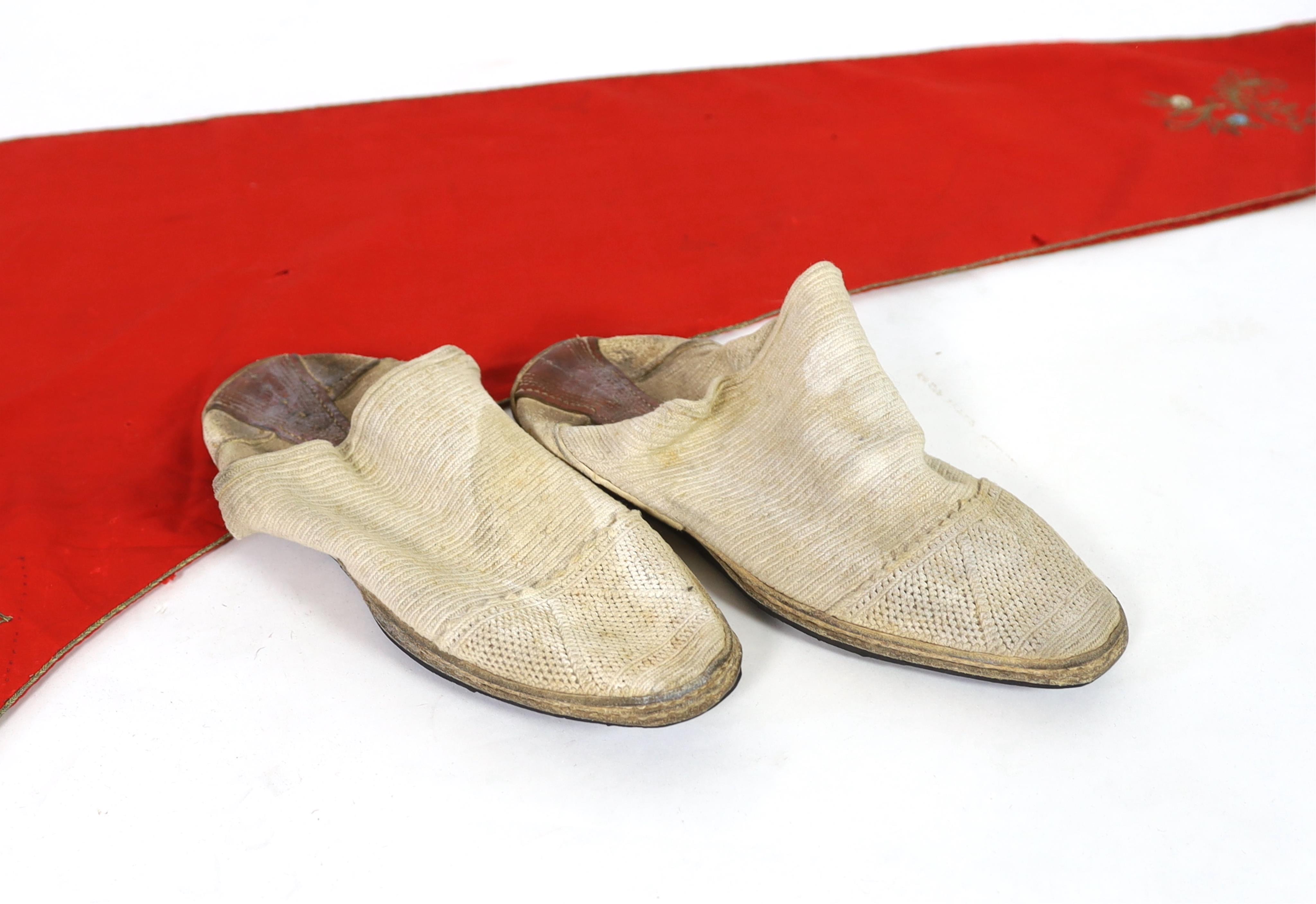 A pair of 1970's Iranian ‘Geevay’ slippers, the soles made from tyres and tops hand crochet together with a 19th century fine red wool hood with gold embroidery and a red tassel, possibly Spanish, ecclesiastical hood